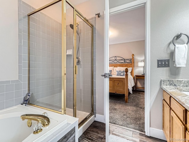 9867 Mulberry Way, Highlands Ranch, CO 80129 - ensuite bathroom featuring a shower stall, a garden tub, vanity, and wood finished floors