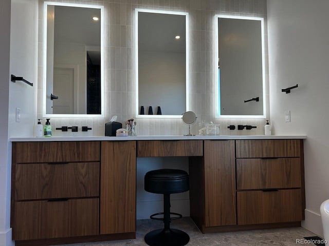 bathroom featuring vanity and backsplash