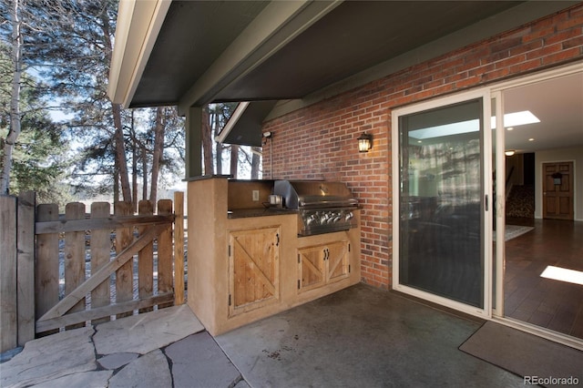 view of patio / terrace featuring area for grilling, fence, exterior kitchen, and a gate