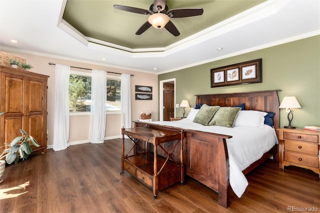 bedroom with ornamental molding, baseboards, dark wood-style flooring, and a tray ceiling