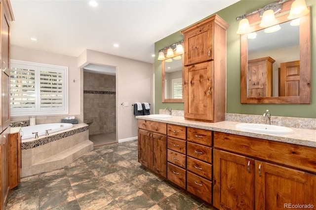 bathroom featuring a bath, walk in shower, a sink, and double vanity