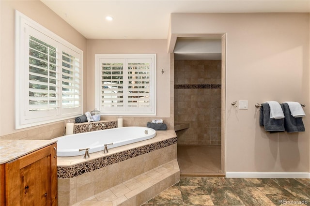 full bath featuring a garden tub, a walk in shower, and baseboards