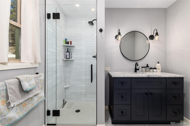 full bath with baseboards, vanity, and a stall shower