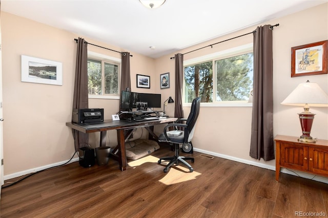 office area featuring baseboards, wood finished floors, and a healthy amount of sunlight
