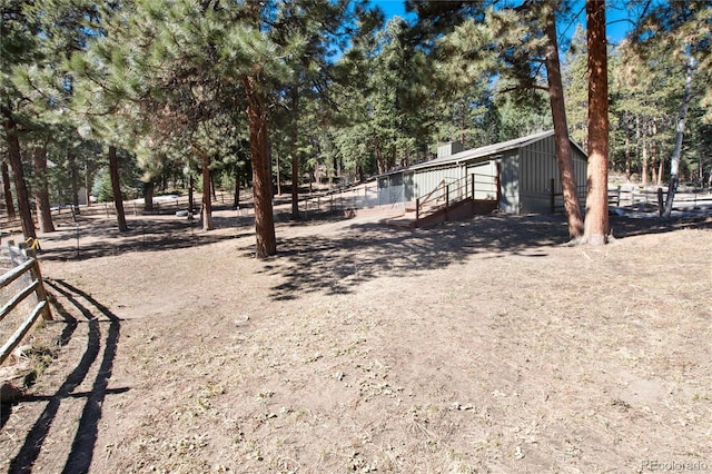 view of yard with an outdoor structure and fence