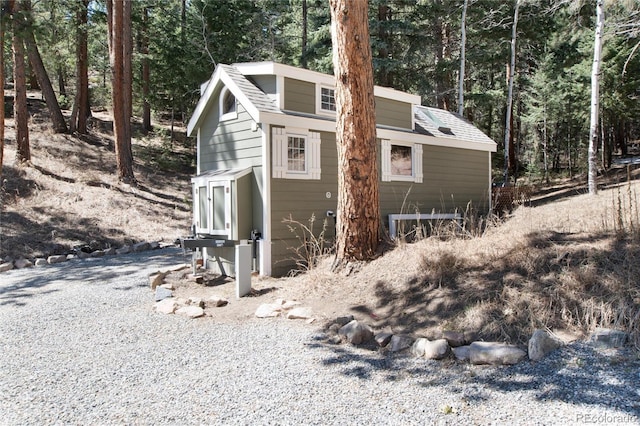 view of outbuilding featuring an outdoor structure and a forest view