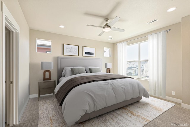 carpeted bedroom with multiple windows and ceiling fan