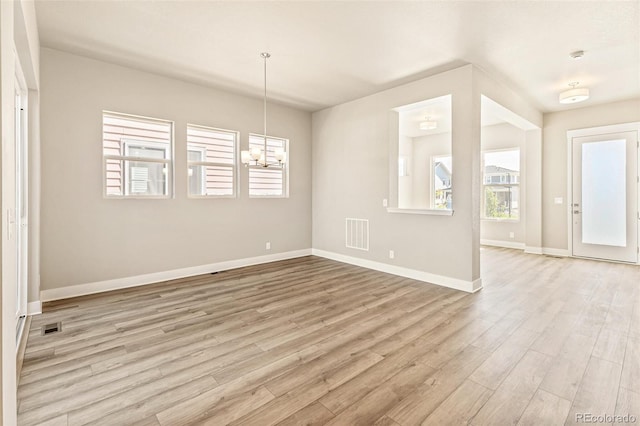 interior space featuring light wood-type flooring and an inviting chandelier