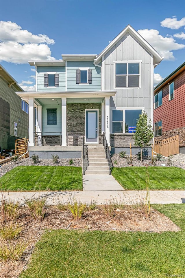 view of front of house with a porch and a front lawn