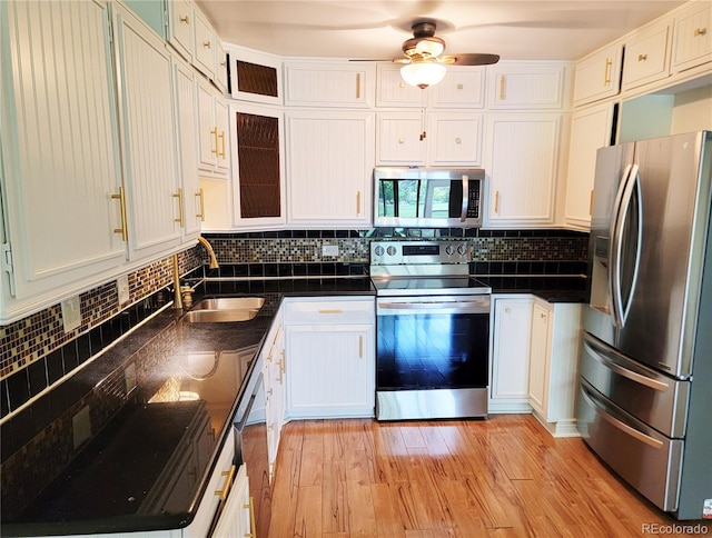 715 S Alton Way Unit 10A, Denver, CO 80247 - kitchen featuring appliances with stainless steel finishes, a sink, white cabinets, and tasteful backsplash