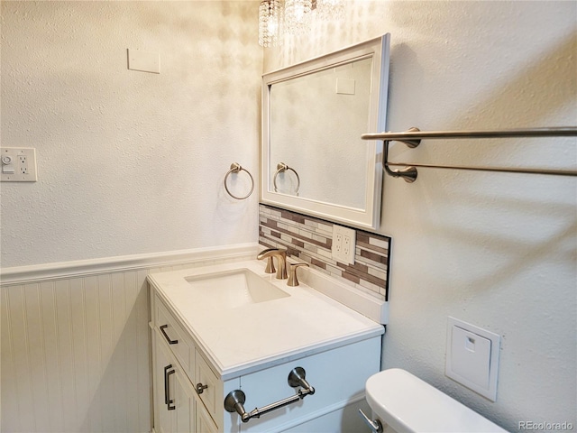 715 S Alton Way Unit 10A, Denver, CO 80247 - bathroom with vanity, toilet, and a wainscoted wall