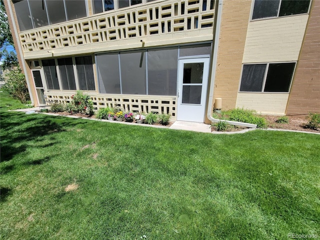 715 S Alton Way Unit 10A, Denver, CO 80247 - back of house featuring a sunroom, brick siding, a balcony, and a lawn