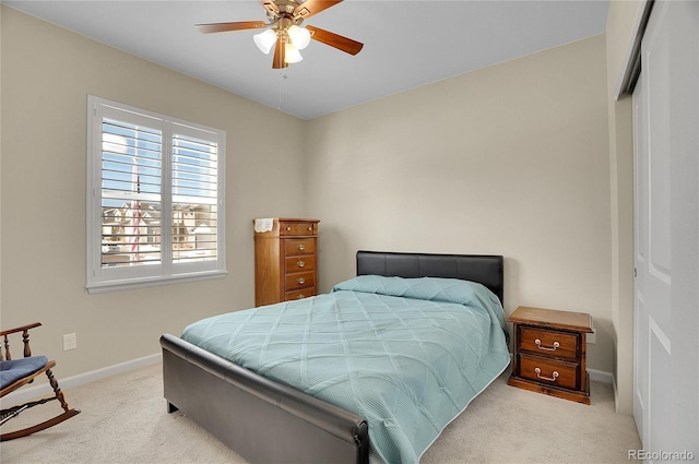 bedroom with light carpet, ceiling fan, and a closet