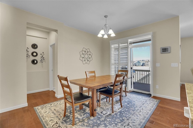 dining area featuring hardwood / wood-style floors and a notable chandelier