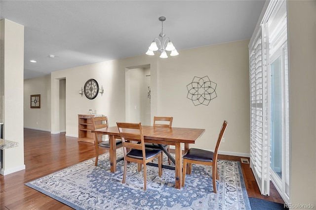 dining space featuring dark hardwood / wood-style floors and a notable chandelier