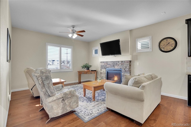 living room with a fireplace, dark hardwood / wood-style floors, and ceiling fan