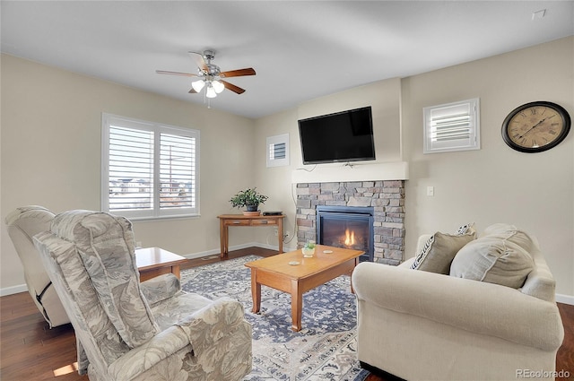 living room featuring ceiling fan, hardwood / wood-style floors, and a fireplace