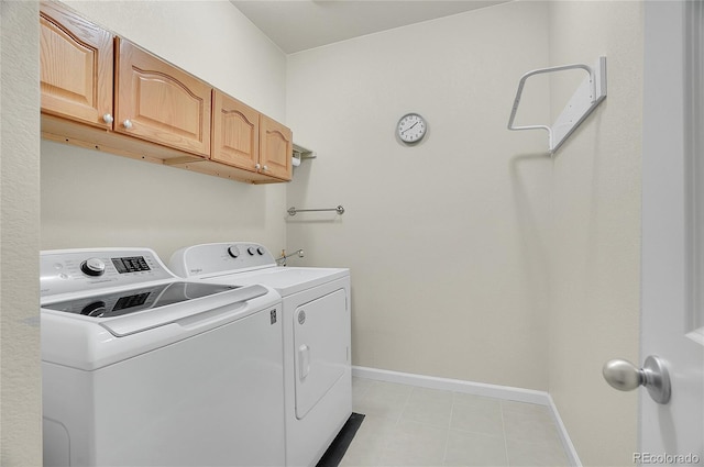 clothes washing area featuring washing machine and dryer and cabinets