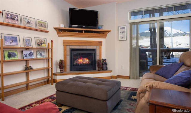 living room featuring carpet and a tiled fireplace