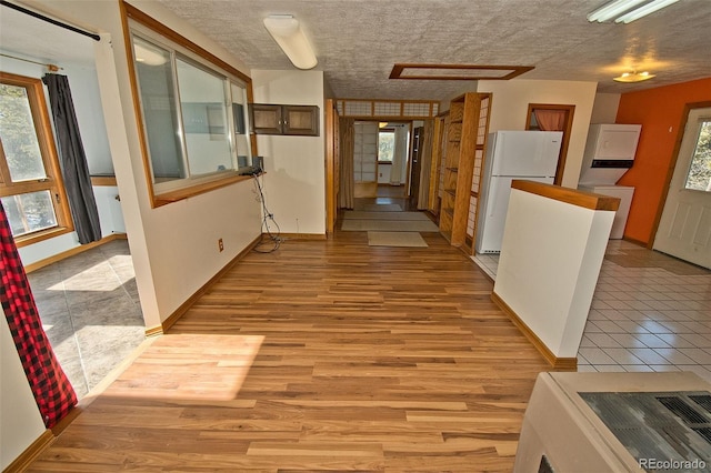 corridor with a wealth of natural light and light hardwood / wood-style flooring