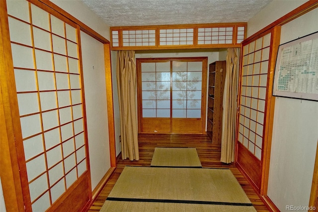 interior space featuring a textured ceiling and hardwood / wood-style flooring