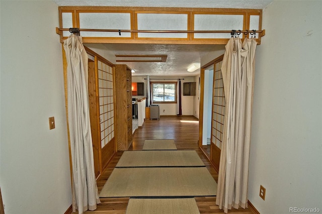 hall featuring hardwood / wood-style floors and a textured ceiling