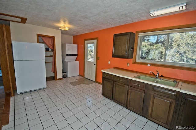 kitchen featuring a wealth of natural light, white refrigerator, dark brown cabinets, and sink