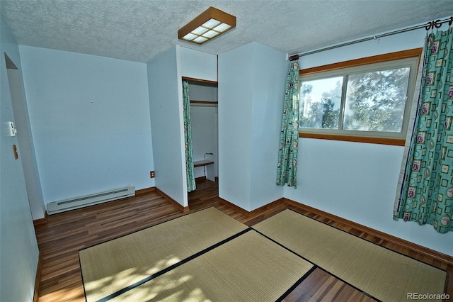 unfurnished bedroom featuring dark hardwood / wood-style floors, a textured ceiling, and a baseboard radiator