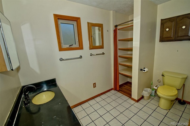 bathroom featuring toilet, a textured ceiling, and vanity