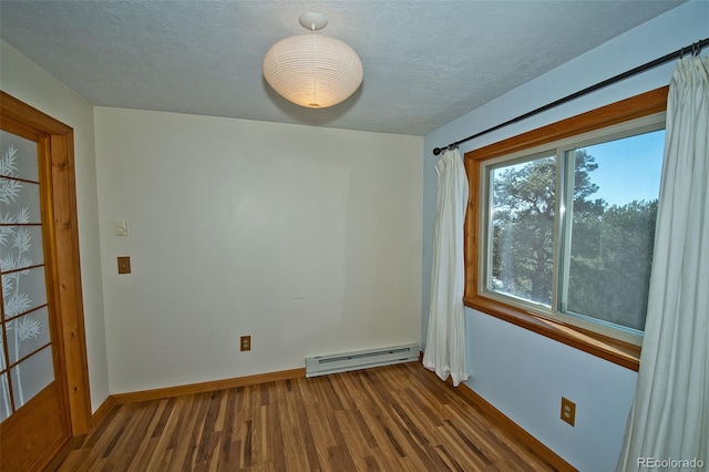 unfurnished room featuring a baseboard heating unit, a textured ceiling, and hardwood / wood-style floors