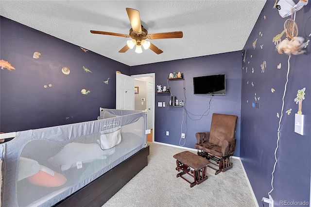 bedroom featuring carpet flooring, ceiling fan, and a textured ceiling