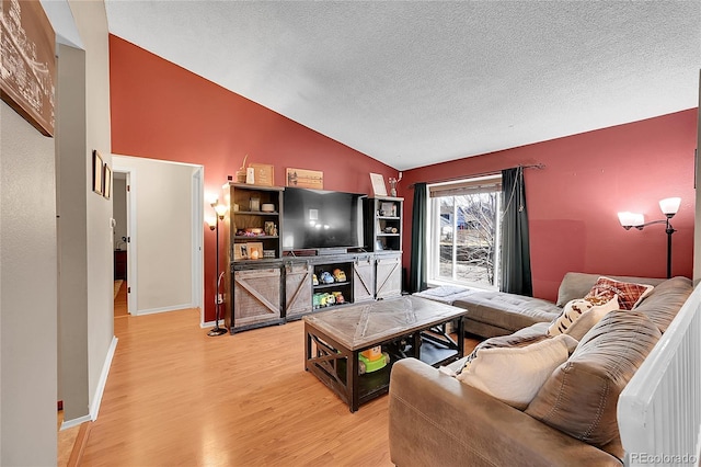 living room featuring a textured ceiling, wood-type flooring, and lofted ceiling