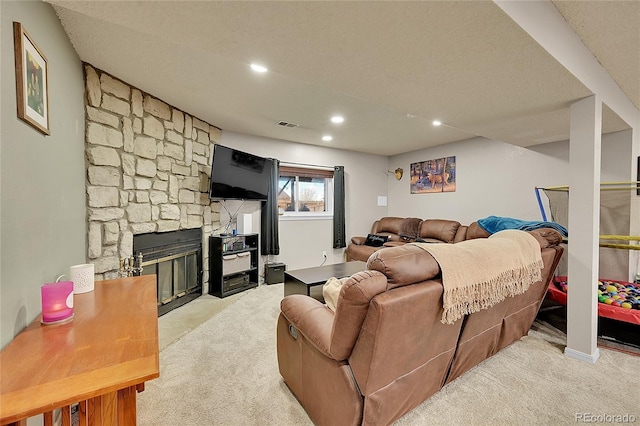 living room featuring light carpet, a fireplace, and a textured ceiling