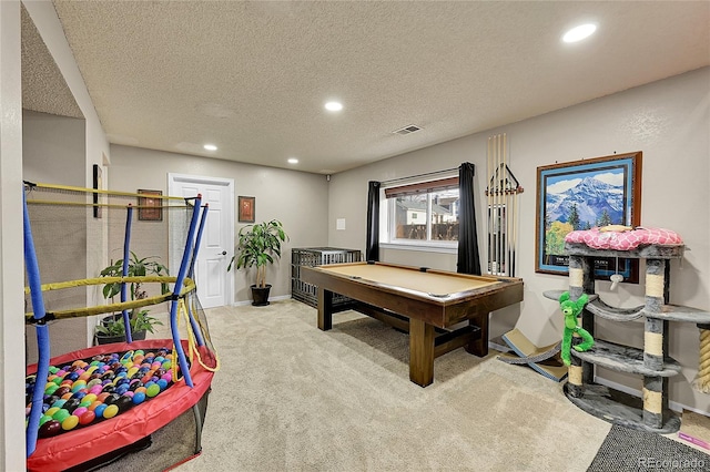 recreation room featuring light colored carpet, a textured ceiling, and pool table