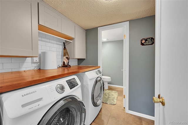 laundry room with independent washer and dryer, a textured ceiling, and light tile patterned floors