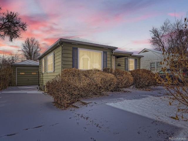 property exterior at dusk featuring a garage and an outbuilding