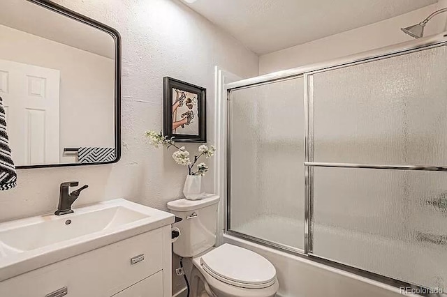 full bathroom with toilet, enclosed tub / shower combo, and vanity with extensive cabinet space