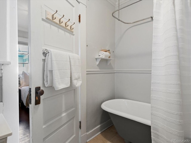 bathroom featuring crown molding and a tub to relax in