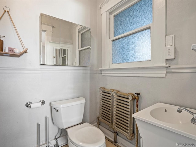 bathroom featuring radiator, toilet, and vanity