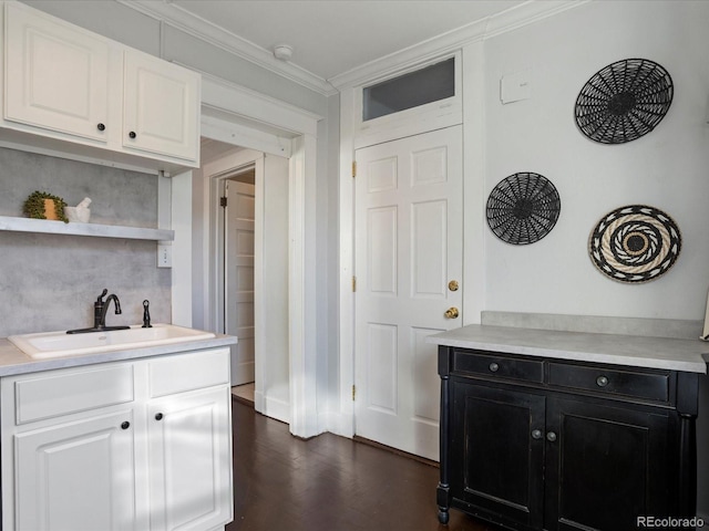 kitchen featuring sink, white cabinets, dark hardwood / wood-style floors, and ornamental molding