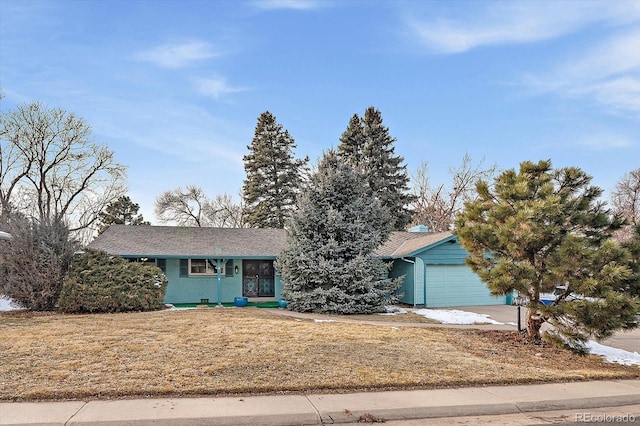 view of front of property featuring a front lawn, concrete driveway, and an attached garage