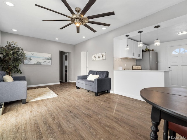 living area with recessed lighting, baseboards, and wood finished floors