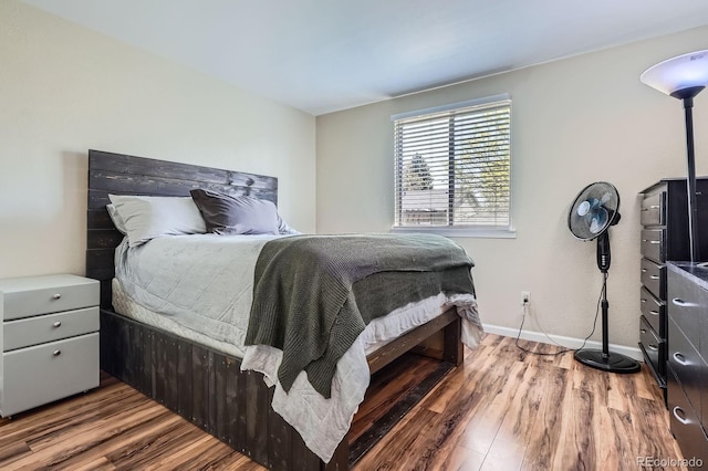 bedroom with wood finished floors and baseboards