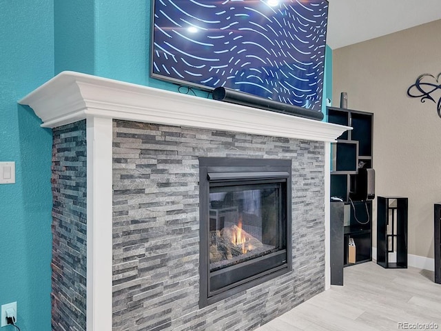 room details featuring hardwood / wood-style flooring and a stone fireplace