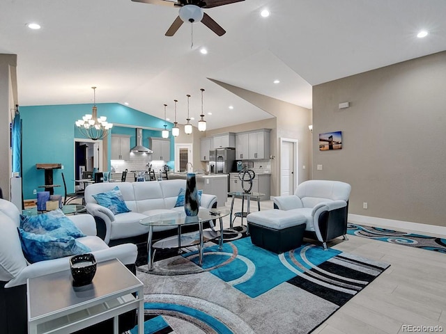 living room featuring vaulted ceiling, ceiling fan with notable chandelier, and light hardwood / wood-style floors