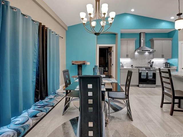 dining room featuring lofted ceiling and light hardwood / wood-style flooring