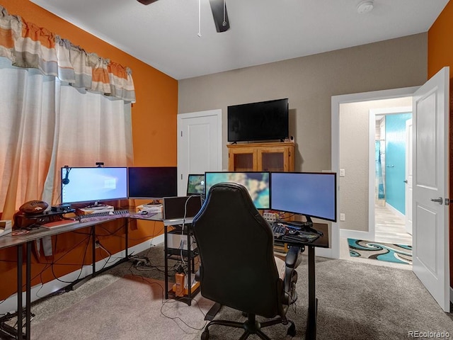 carpeted office space featuring ceiling fan