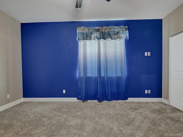 carpeted spare room with ceiling fan