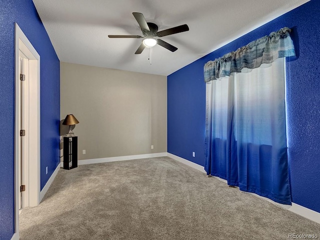 carpeted spare room with ceiling fan