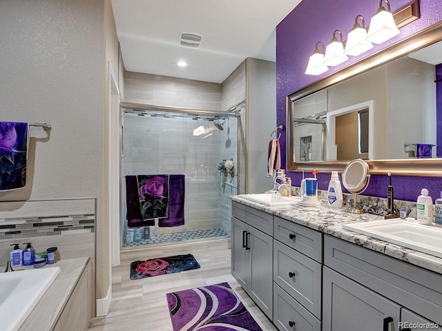 bathroom with vanity and shower with separate bathtub